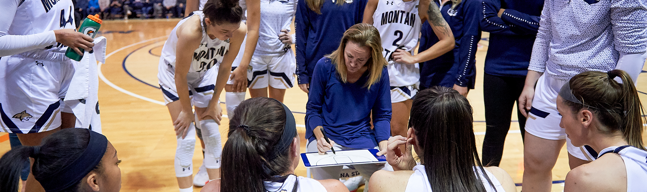 Coach watches team from sidelines