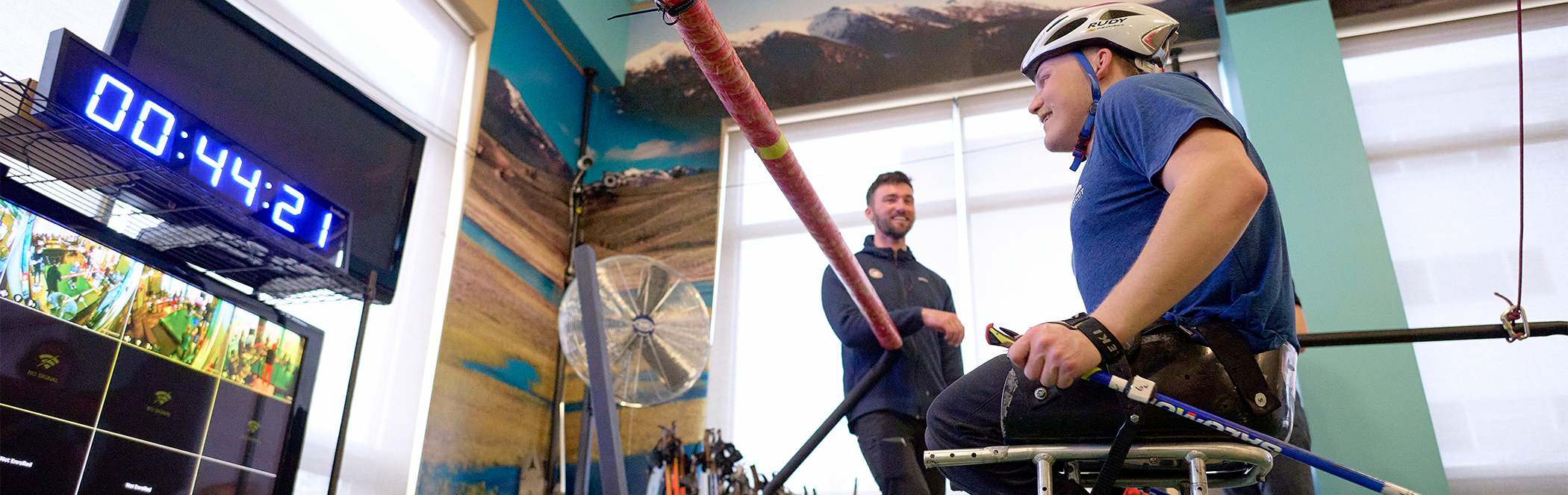 A man, depicted from the knees down, runs on a treadmill with various sensors connected to his legs.
