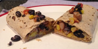 An image of a southerwestern lunch wrap cut in half on a white plate.