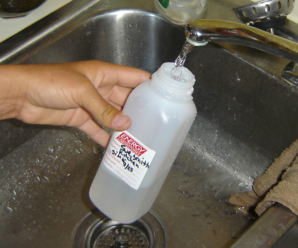 a sample container collecting water from a faucet
