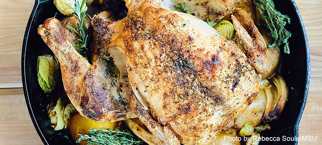 lemon-garlic roast chicken with vegetables in a cast iron frying pan