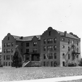 Hamilton Hall is a four-and-a-half story brick building with distinctive mission revival-style parapets.