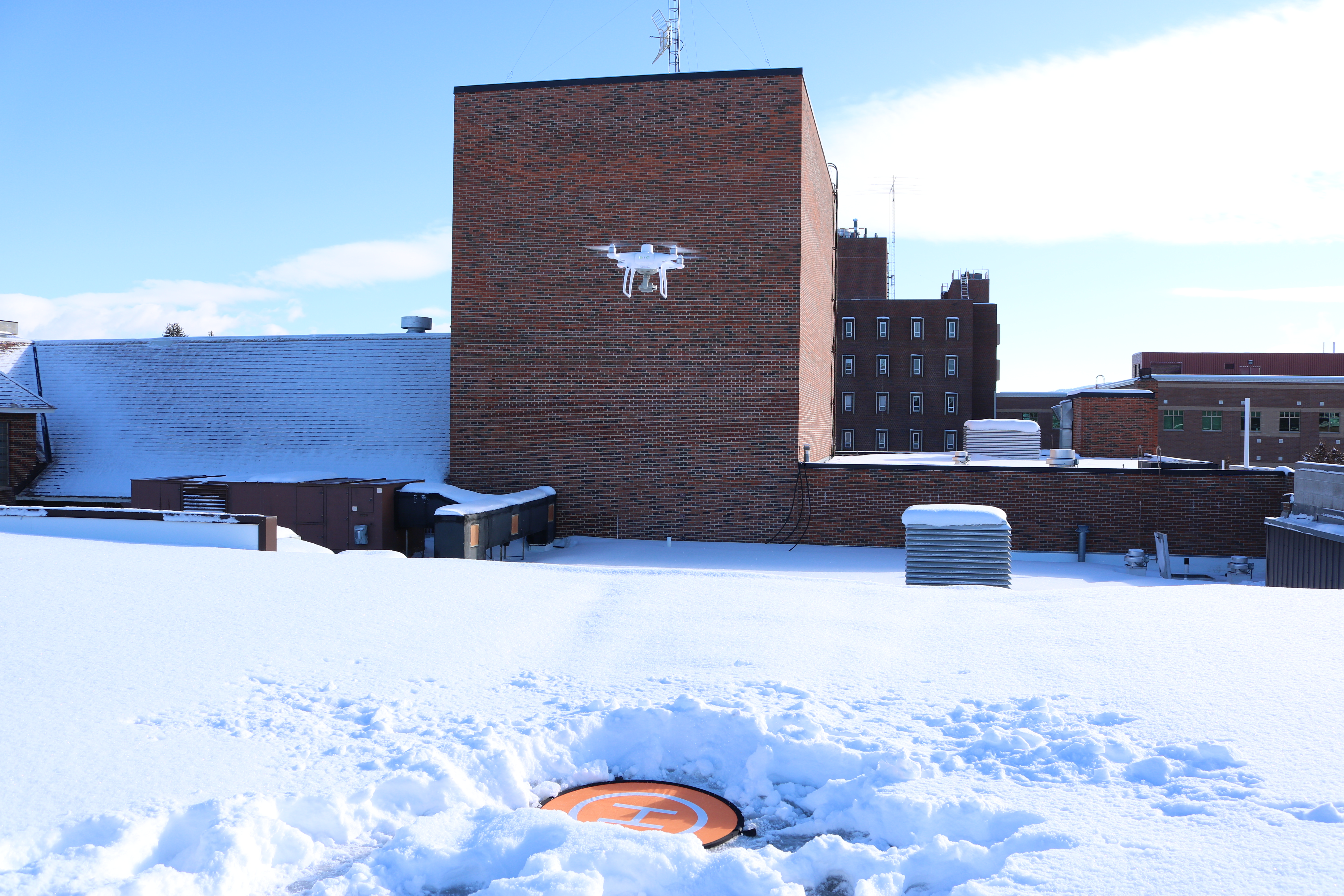 Drone lands on a in snow covered flat roof top