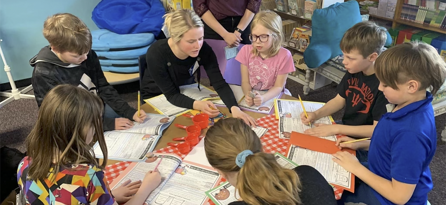 teacher with students at table