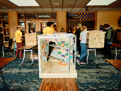 A wooden student project on top of a table in a classroom